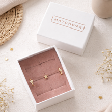 Load image into Gallery viewer, Star-shaped earrings in a 'Matchbox' jewelry box on a light surface with decorative elements.