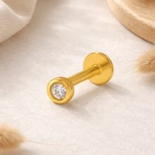 Load image into Gallery viewer, Gold barbell earring with a clear gemstone on a beige fabric background