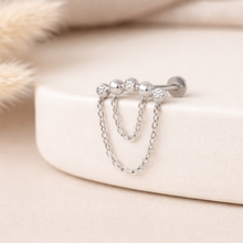 Load image into Gallery viewer, Silver earring with chain detail on a soft beige background

